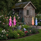 Solar delphinium flower lights glowing in a residential patio garden at night