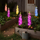 Solar delphinium flower lights decorating a farmhouse garden at night