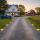 Solar disk pathway lights positioned along the edges of a gravel driveway at night
