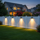 Luces solares para cercas iluminando al anochecer una cerca clásica en el patio trasero de una casa suburbana