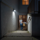 Luz solar de pared con sensor de movimiento sobre una entrada de sótano para iluminación de seguridad nocturna