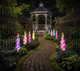 Solar delphinium flower lights glowing in a Victorian-style garden after dark