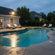 Foco solar iluminando una zona de piscina por la noche