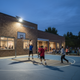 Foco solar iluminando por la noche una cancha de baloncesto de un centro comunitario