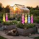 Solar delphinium flower lights adding decorative illumination to an herb garden after dark
