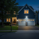 Foco solar iluminando un garaje residencial y la entrada de vehículos por la noche