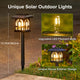 House-shaped solar garden light illuminated at night with warm light shining through its window-style openings