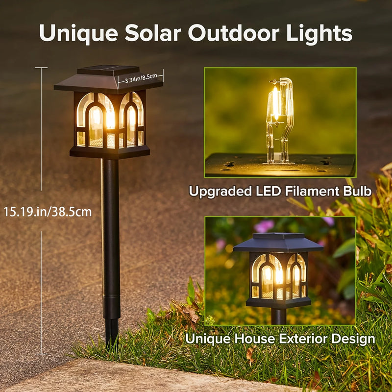 House-shaped solar garden light illuminated at night with warm light shining through its window-style openings