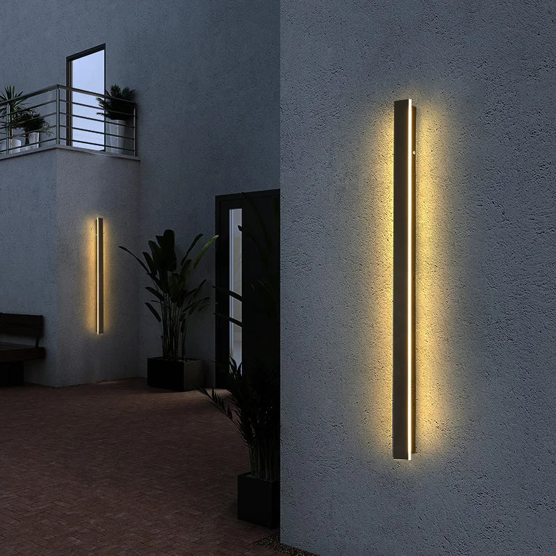 Close product view of a long-strip LED wall light showing its slim black housing and elongated lighting section