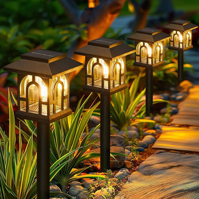 Mini house-shaped solar pathway light with warm white LED glow and ground stake for decorative garden and lawn lighting