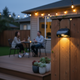 Luces solares para cercas iluminando al anochecer un patio moderno junto a guirnaldas de luces decorativas