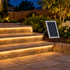 Warm-white solar COB rope lights outlining stone patio steps beside a solar panel at night.