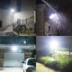 Foco solar iluminando escalones, paredes, un garaje y un patio bajo la lluvia