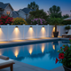 Luces solares para cercas iluminando al anochecer una cerca junto a la piscina de una villa de lujo