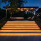 Tiras LED COB solares blanco cálido bajo escalones de patio que conducen a una zona cubierta del patio trasero al anochecer