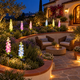 Solar delphinium flower stake lights distributed along curved raised flower beds surrounding a Southern California patio seating area at night.
