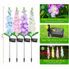 Decorative solar delphinium flower lights glowing among garden plants to add floral accent lighting after dark