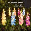 Solar delphinium flower light shown with its long stem and pointed ground stake for placement in soil and garden beds