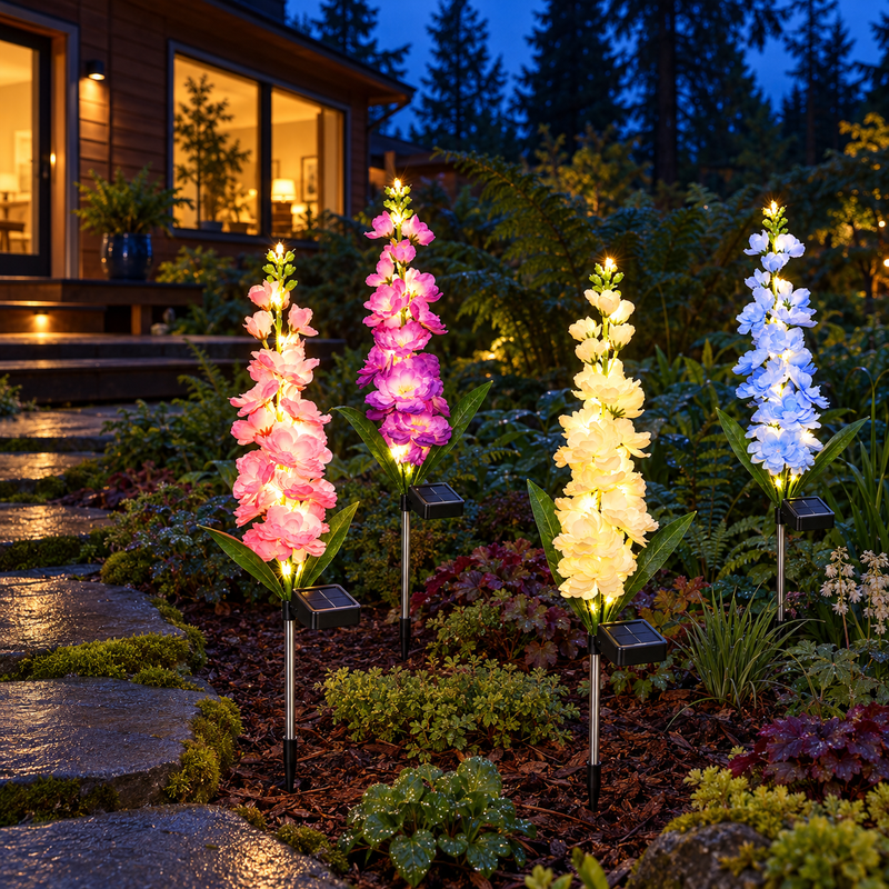 Four illuminated solar delphinium flower stakes in a Pacific Northwest cedar house garden at blue hour, with moss-edged basalt stepping stones, ferns, upward-facing solar panels and visible silver stems.