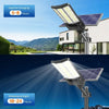 Commercial solar flood light shown with remote controls for brightness, timer and automatic nighttime lighting settings