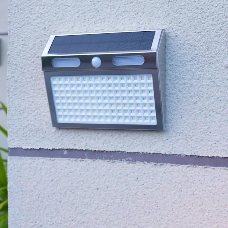 Aplique solar con sensor de movimiento iluminando de noche una zona exterior en entradas, garajes, patios y jardines traseros