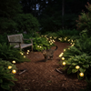 Solar mushroom stake lights glowing along a woodland garden path at night