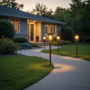 Solar pathway lights illuminating suburban front yard walkway at dusk