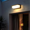 Solar motion sensor security light installed on a garden wall to illuminate nearby plants and walking areas after dark