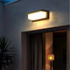 Solar motion sensor security light installed on a garden wall to illuminate nearby plants and walking areas after dark