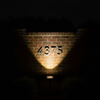 Solar spotlight as sole light source illuminating house numbers at night