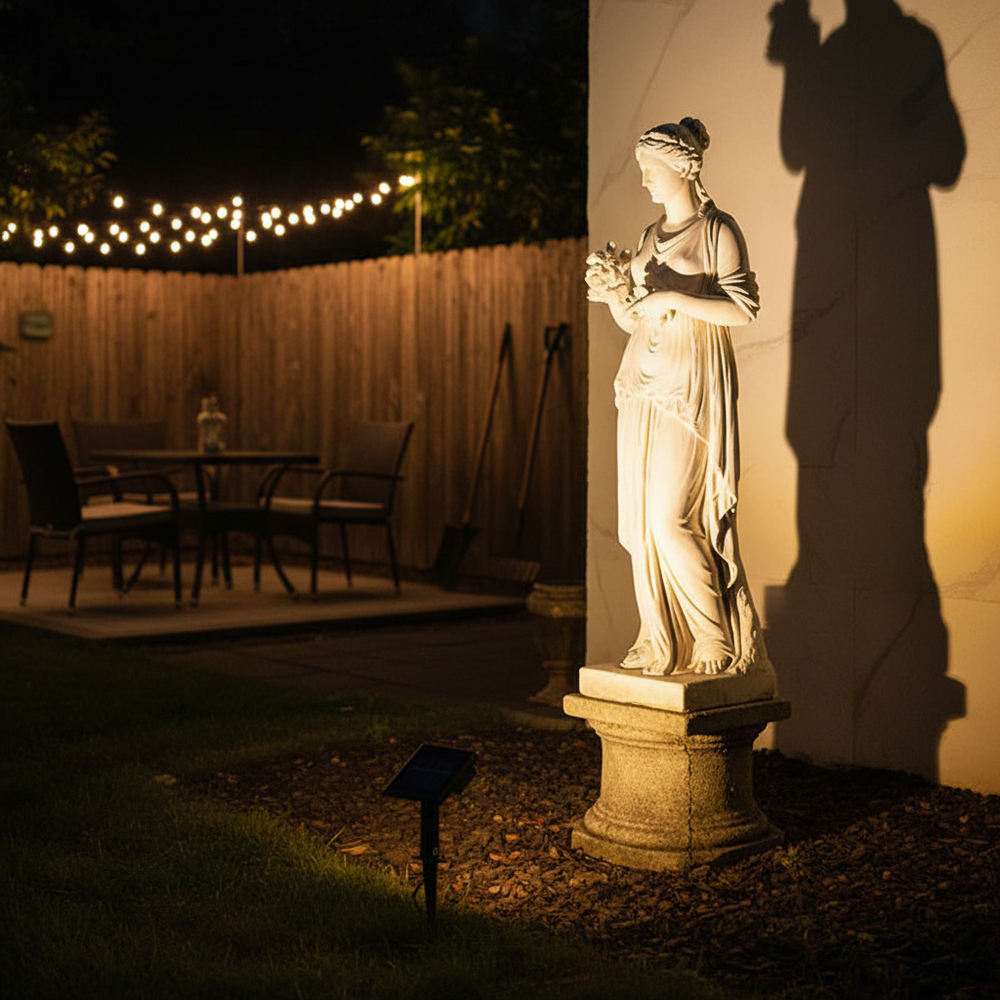 Solar spotlight on garden statue in American backyard at night