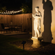 Foco solar iluminando de noche una estatua de jardín en un patio trasero estadounidense