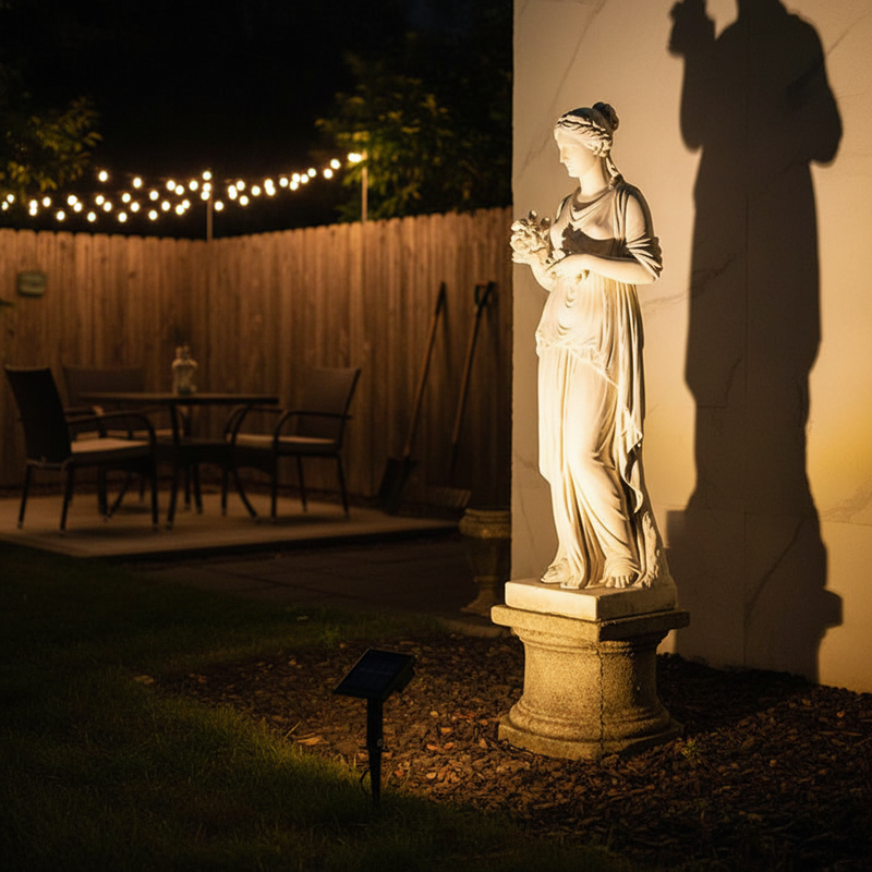 Solar spotlight on garden statue in American backyard at night | NoxLumin