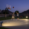 Solar spotlights illuminating backyard basketball court