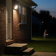 Aplique solar con sensor de movimiento de 112 LED iluminando de noche una puerta trasera residencial