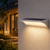 Applique solaire LED installée à l’extérieur avec panneau solaire intégré au-dessus de la zone d’éclairage à détecteur de mouvement