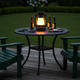 Linterna de camping vintage recargable dando luz cálida sobre una mesa de patio al anochecer